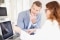 Businesswoman using her digital tablet while sitting at office desk with her thinking colleague and having discussion. Teamwork at the office. ; Shutterstock ID 1152777740; Purchase Order: Energy Images; Job: ; Client/Licensee: Jeannette Kunde; Other: 